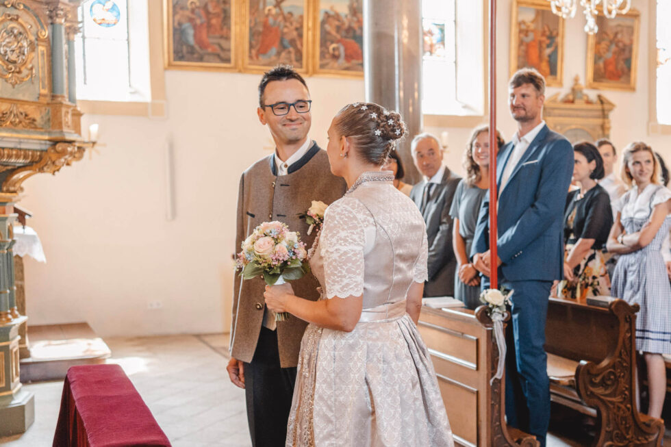 Bräutigam sieht seine Braut verliebt an bei einer kirchlichen Trauung fotografiert von einer Hochzeitsfotografin in München