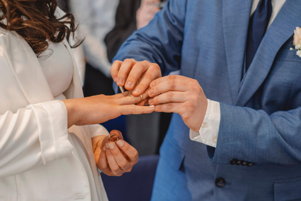 Bräutigam steckt seiner Braut im Standesamt den Ring an den Finger fotografiert von einer Hochzeitsfotografin in München