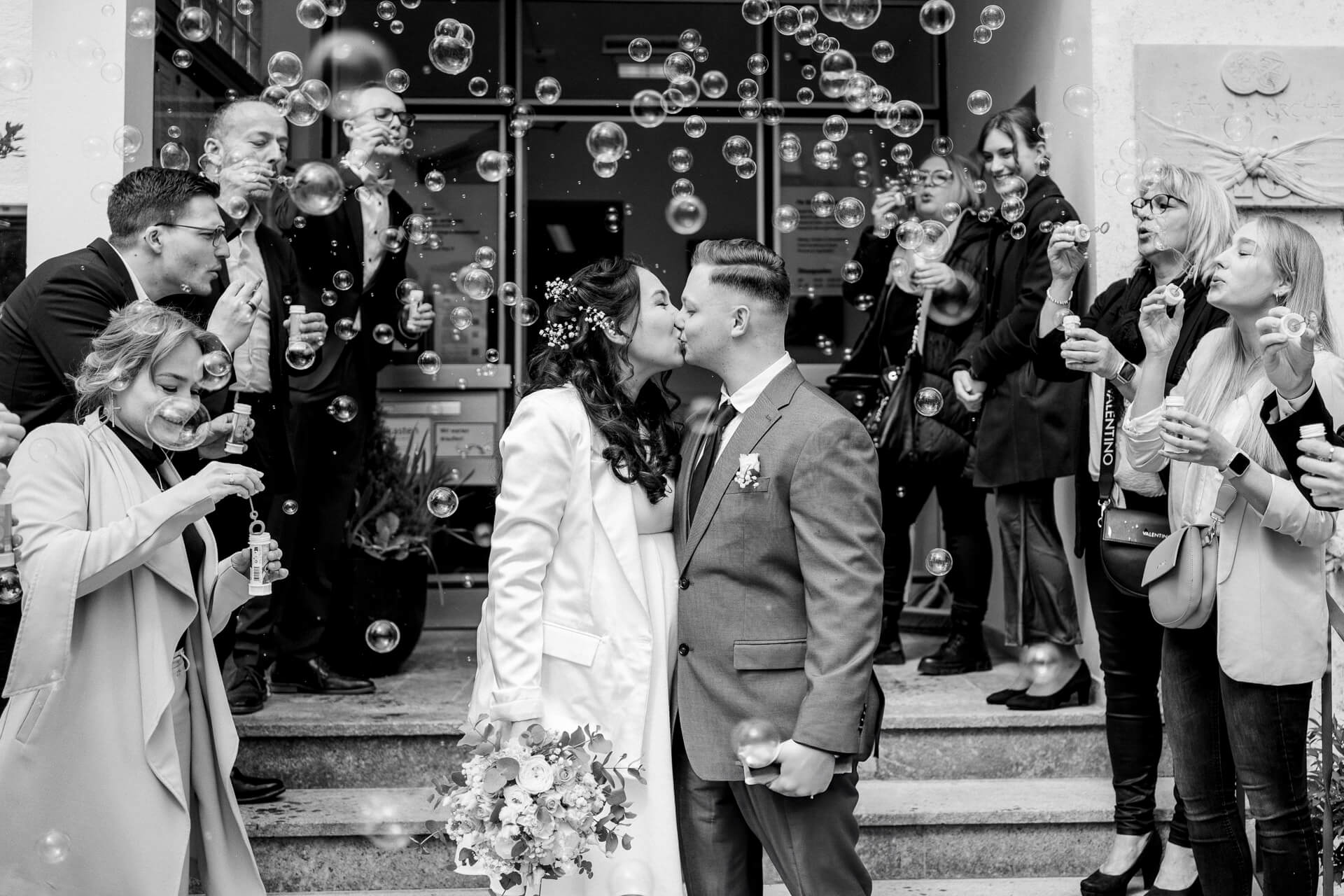 Hochzeitspaar küsst sich vor Standesamt fotografiert von einer Hochzeitsfotografin in München