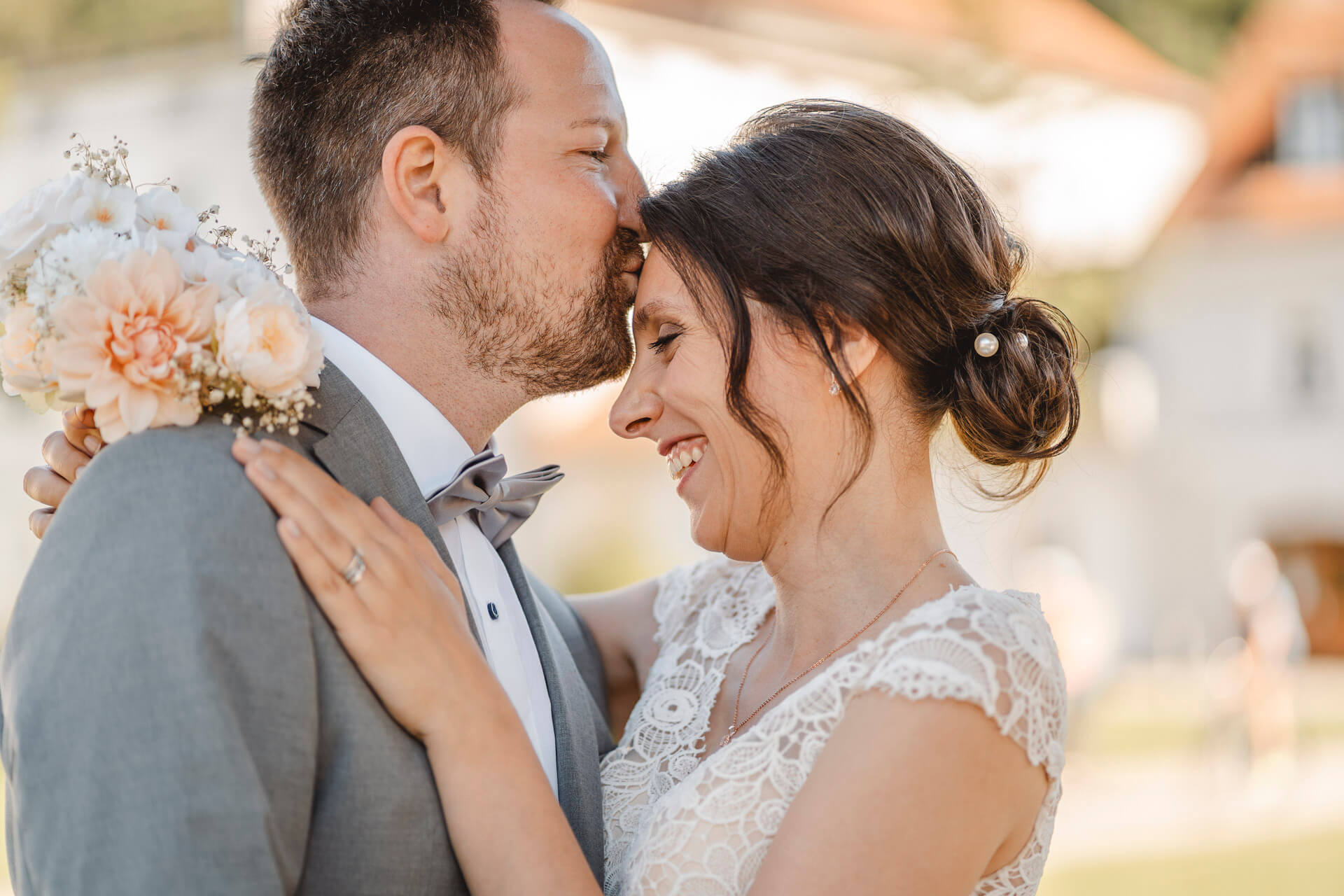 Hochzeitsfoto auf dem ein Bräutigam seiner Braut einen Kuss auf die Stirn gibt fotografiert von einer Hochzeitsfotografin in München