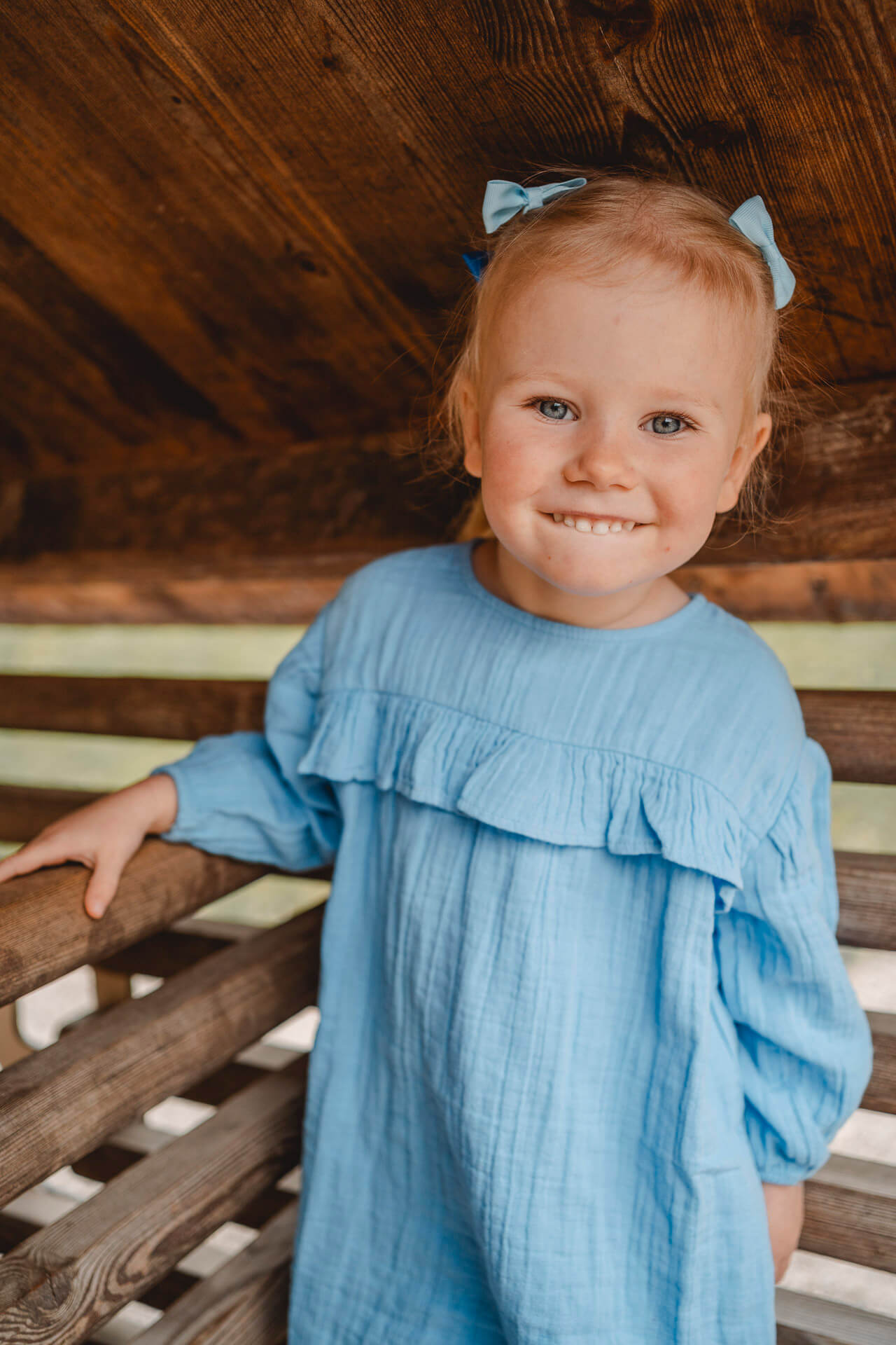 Kindergartenfoto von einem Mädchen in einem Spielhaus, das grinsend die Zunge heraus streckt